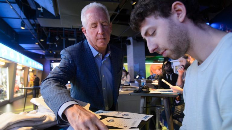 Former NFL head coach John Fox, left, advises participating media members during an April 11 mock draft at NFL Experience Times Square
