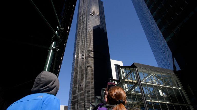 A person takes a photo of the fire-damaged apartment on the 50th floor of Trump Tower on Sunday, the day after the blaze. 