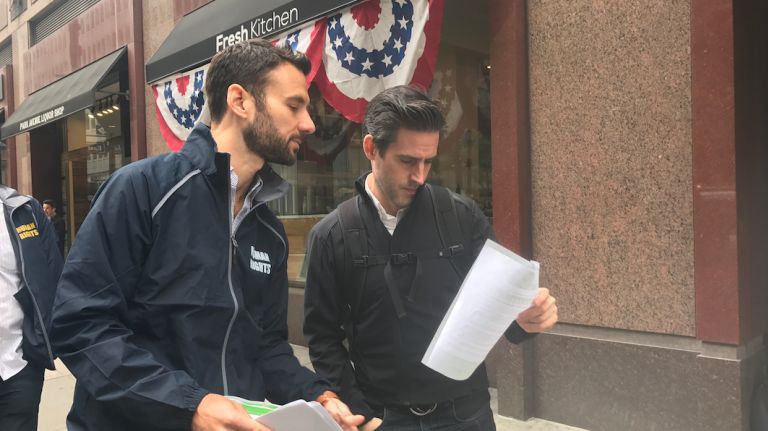Seth Hoy, left, with the NYC Commission on Human Rights, handed out flyers to passersby outside of Fresh Kitchen on Friday.