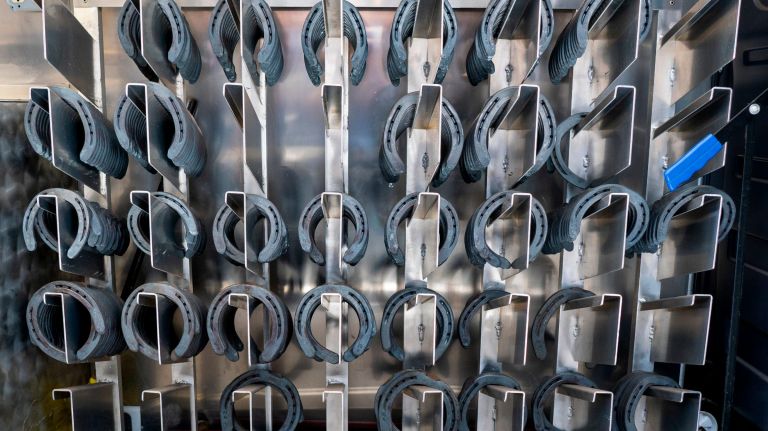 Horseshoes of different shapes and sizes hang on the inside of the mobile shop.