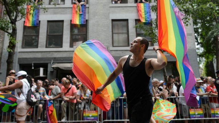 Pride parade NYC: Photos of the 2018 march through Manhattan 56 A marcher waves flags as they parade down the street.