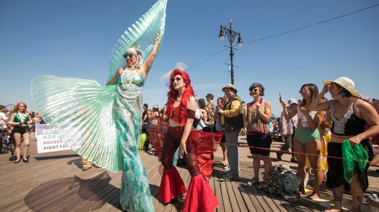 Glamorous mermaids perform on the boardwalk.
