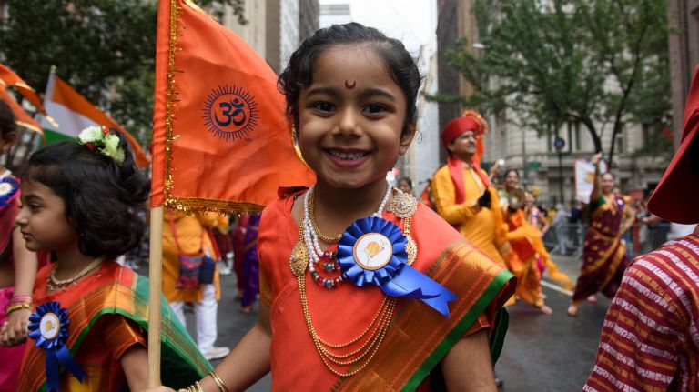 A young participant smiles as she proudly marches.
