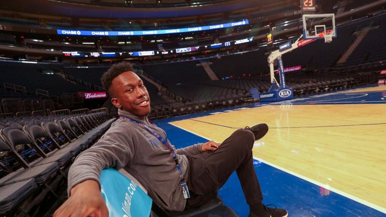 Anthony Aiken, who has been a tour guide at MSG for three years, sits courtside in "celebrity row."