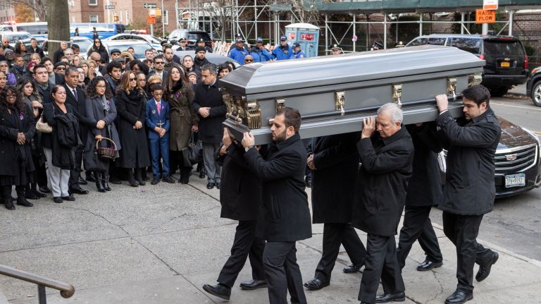 Mourners watch as the casket is brought into Saint Joan of Arc Roman Catholic Church in Jackson Heights during the funeral for State Sen. Jose Peralta on Tuesday.