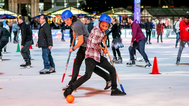 Mert Ozer and Kevin Omonua, both of&nbsp;Brooklyn both go for control of the ball as they learn to play broomball at the Rink at Bryant Park on Nov. 7, 2018.