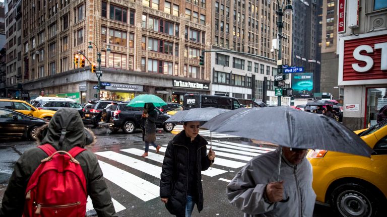 Pedestrians cross the intersection of&nbsp;Eighth&nbsp;Avenue and 35th Street in Manhattan during Friday's storm.