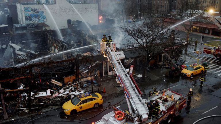 Firefighters respond to a five-alarm fire in a strip of commercial buildings on Queens Boulevard in Sunnyside, Queens, on Thursday.