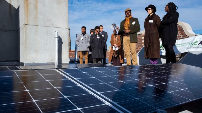 Solar panels on a co-op in Harlem will offset the cost of energy in the building's common spaces. Above,&nbsp;Cecil Corbin-Mark of WE ACT&nbsp;for Environmental Justice, third from right, speaks at a news conference about the panels on Wednesday.