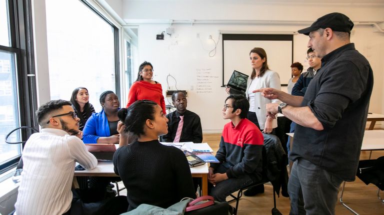 Dan Teper, right, managing director of Brookfield Asset Managment's Real Estate Investments, works with students on their presentation.