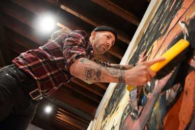 Artist Scooter LaForge in his studio working with an unusual brush.