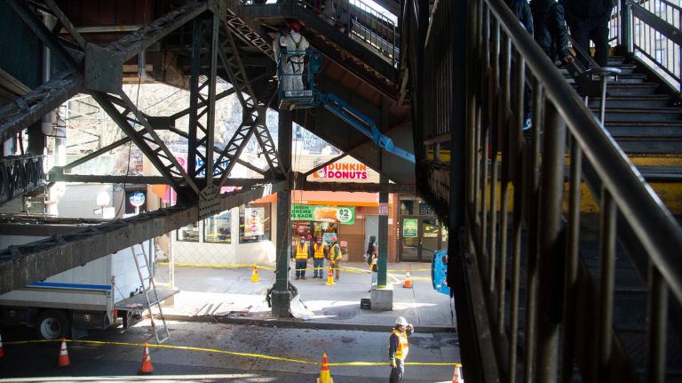 New York City Transit workers remove potentially hazardous pieces of metal from the elevated 7 train platform at the 61st Street-Woodside station in Queens on Wednesday.