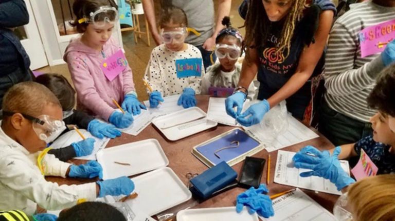 Yvonne Thevenot, right, goes over a dissection with elementary school kids during one of STEM Kids NYC's programs.