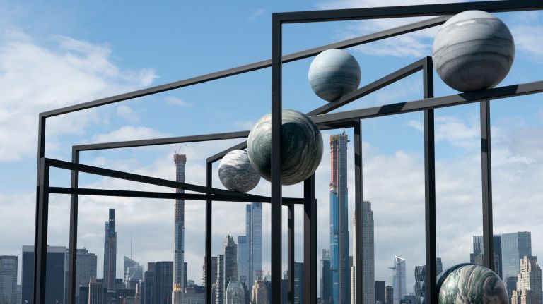 Berlin-based artist Alicja Kwade's "ParaPivot I and II" sculptures are displayed on the Iris and B. Gerald Cantor Roof Garden at the Metropolitan Museum of Art. The sculptures consist of nine spheres nestled in powder-coated steel frames that intersect at oblique angles.