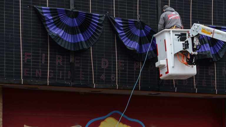 A firefighter hangs&nbsp;bunting at&nbsp;Ladder Company 27 in the South Bronx on Tuesday.