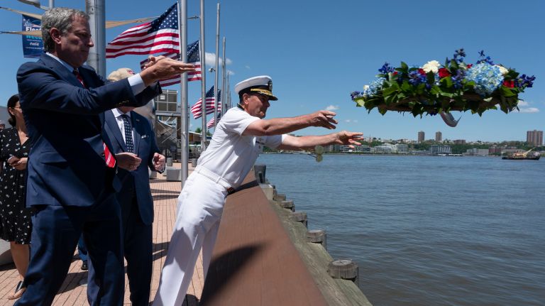 Mayor Bill de Blasio, left, and U.S. Navy Admiral Bill Moran throw a wreath into the Hudson River to honor fallen servicemen and women.
