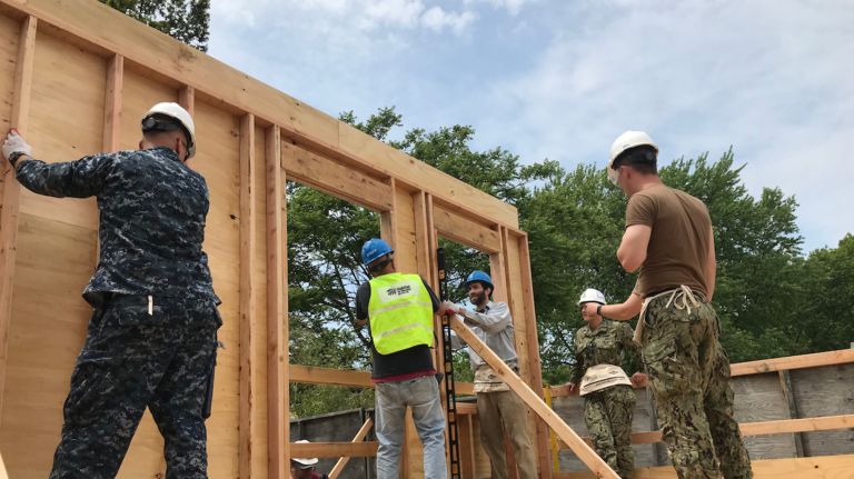 Members of the military visiting New York City for Fleet Week volunteer with Habitat for Humanity to build an affordable home in Queens.