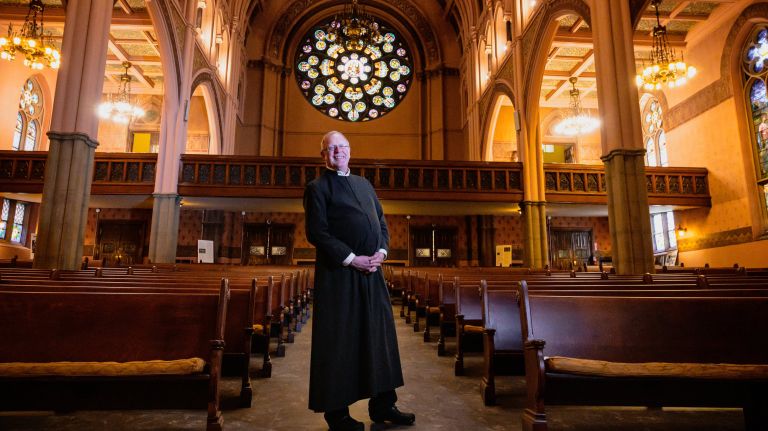 The Rev. Dr. Daniel Meeter stands in the restored sanctuary of the Old First Reformed Church in Park Slope.