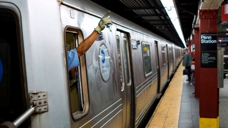 A subway train conductor signals arrival as an A train arrives at Penn Station in Manhattan on Aug. 14, 2018.