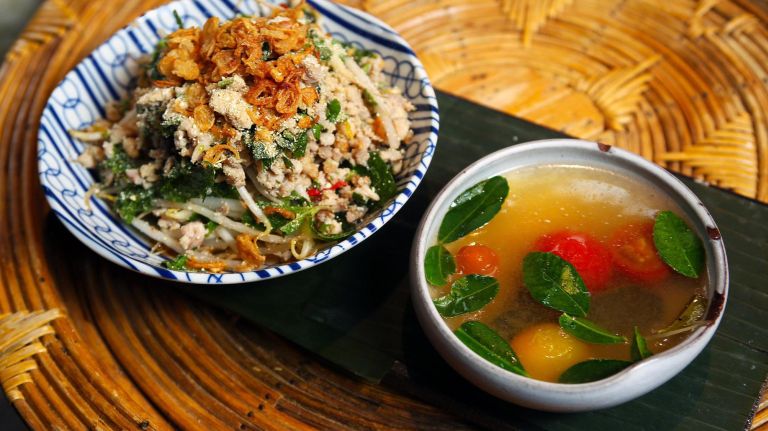 The Lao way to serve laap, Schwader says, is with soup, and he suggests eating a bite of the minced chicken dish with sticky rice, followed by a spoonful of soup (here, sweet and sour).