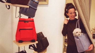 Kate Spade poses with some of the hand bags that she designs and produces. Her dog, Henry, also poses.