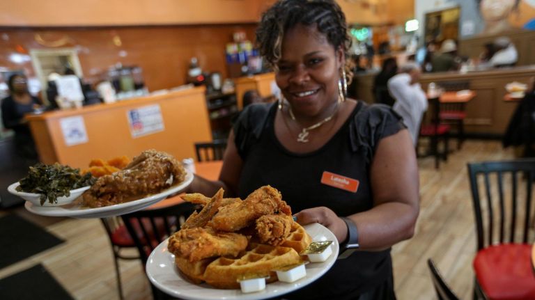 A Harlem tour, complete with restaurant, bar and museum picks 10 Latesha Andreson of Amy Ruth's holds the restaurant's popular chicken and waffles on June 26, 2019.