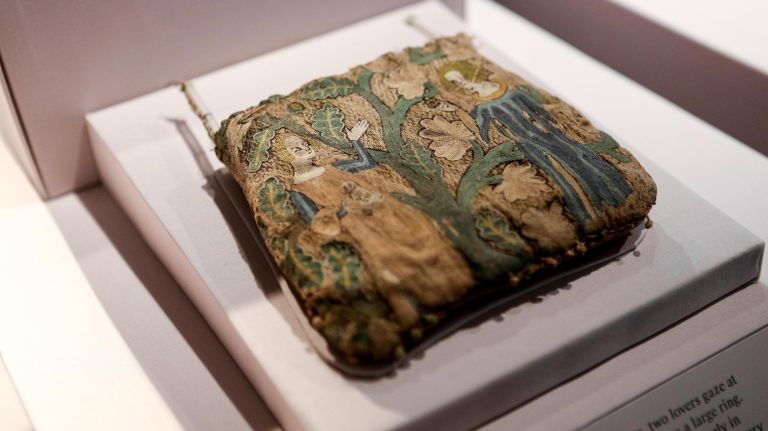 A linen and silk purse is among the artifacts on display.