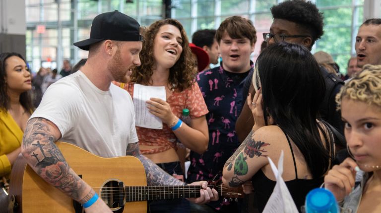 "American Idol" hopefuls huddle together to sing before their auditions at the Brooklyn Expo Center.&nbsp;