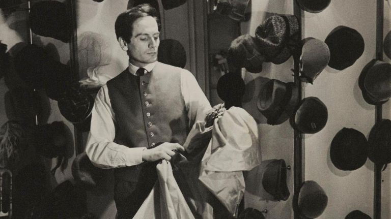 Pierre Cardin poses with fabric in his couture salon in 1952.
