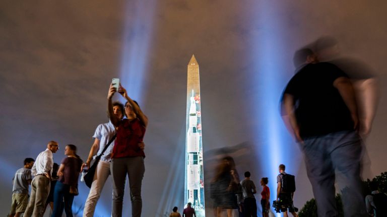 Let's aim to soar above our divides 2 An image of the 363-foot Saturn V rocket, used by the Apollo 11 moon mission, is projected onto the Washington Monument in Washington, D.C.