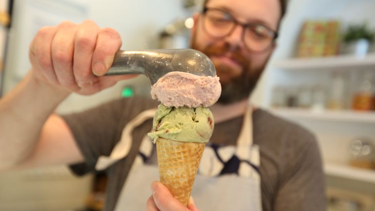 Sugar Hill Creamery co-owner Nick Larsen scoops strawberry-basil and blackberry-pistachio&nbsp;flavors.