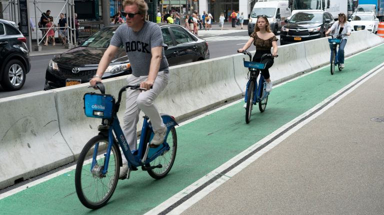 Bicyclists ride in a protected bike lane on 6th Avenue next to Herald Square, Manhattan, Wednesday, July 3, 2019. The NYPD is ramping up enforcement on dangerous driving conditions, such as parking in bike lanes, as cycling injuries increased 9.2 percent&Ecirc;in the first five months of the year.