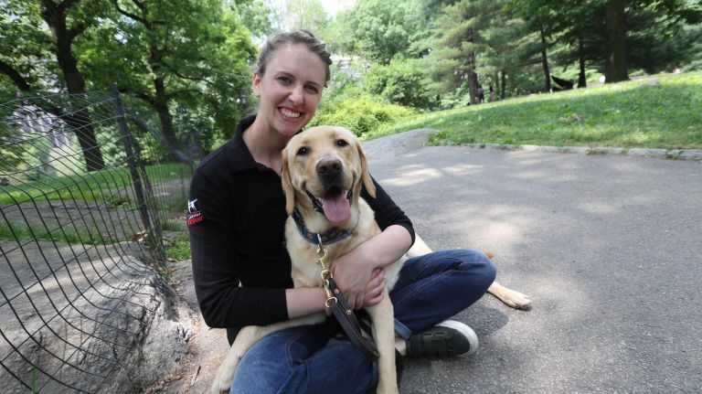 Olivia Poff, a guide dog mobility instructor with the Guide Dog Foundation, sits&nbsp;in Central Park with Sunny.&nbsp;