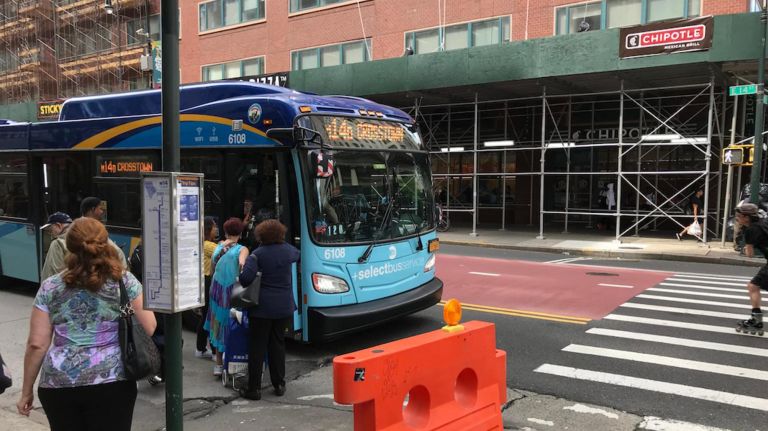 An MTA bus picks up passengers outside the Tech Training Center construction site.