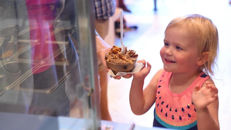 Madeline McCormick, 3, reaches for her ice cream from her mom, Jess McCormick, at Four Winters.