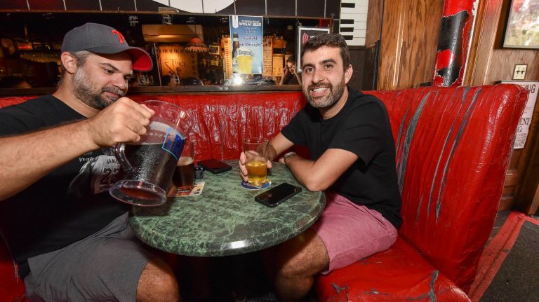 Fabio Angheben and Rafael Mendoonca drink beer at one of Rudy's classically unfancy booths.