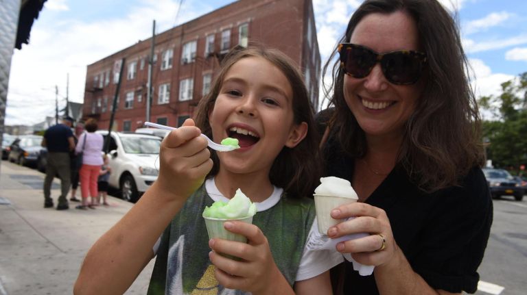 Evander Tomaschett, 10, and his mom Jennifer Fiore enjoy their ices just outsidie The Lemon Ice King of Corona.