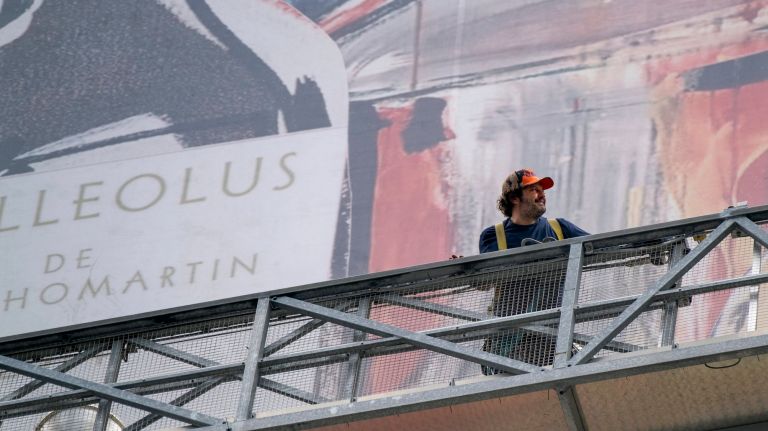 Times Square serves as canvas for city's largest vinyl mural 2 Pop artist Domingo Zapata, standing on a suspended rig several floors over Times Square at Seventh Avenue and 42nd Street, smiles as he works on his mural at One Times Square on Friday.