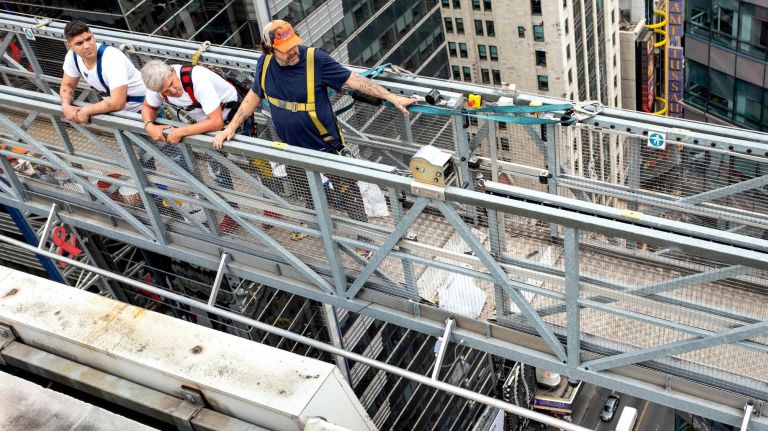 Times Square serves as canvas for city's largest vinyl mural 3 Domingo Zapata, right, stands with part of his team as they descend One Times Square on a suspended rig before working on his mural on the side of the building on Friday.