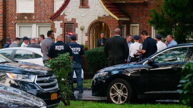 Police gather outside the Laurelton home of an off-duty NYPD officer who died from a self-inflicted gunshot wound on Aug. 14.
