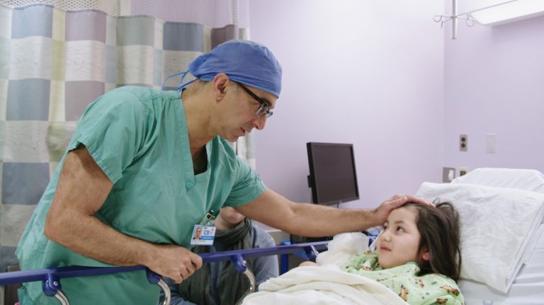 Dr. Saadi Ghatan reassures Sadie Gonzalez before her surgery to implant an electrical device meants to control her seizures.