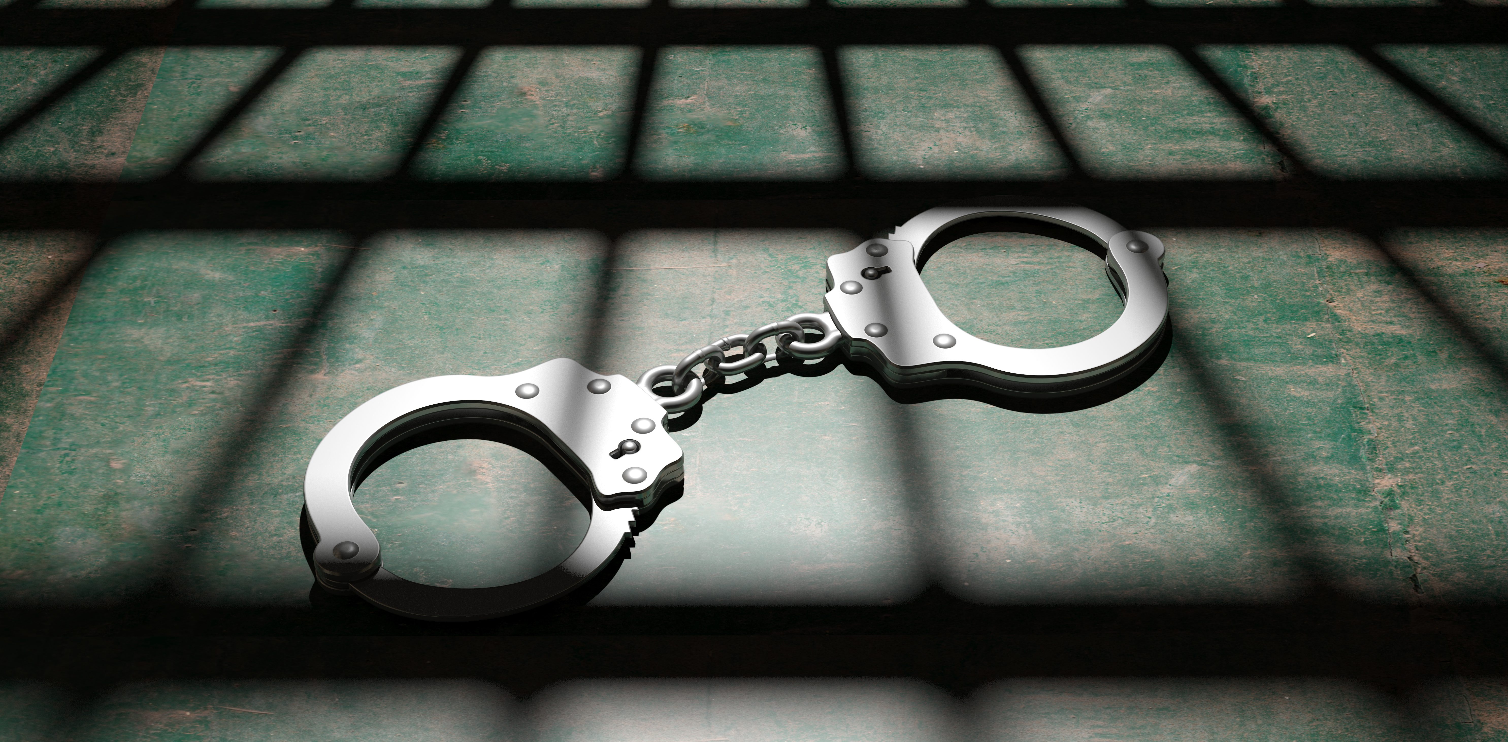 Prison concept. Jail bars and handcuffs, dark background. 3d illustration