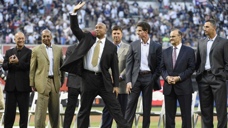 Former New York Yankees centerfielder Bernie Williams waves to the fans as Yankees greats look on during a ceremony to retire Williams' No. 51 before a game between the Yankees and the Texas Rangers at Yankee Stadium on Sunday, May 24, 2015.