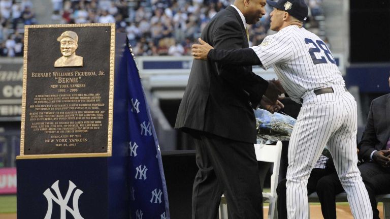 Former New York Yankees Bernie Williams is congratulated by Yankees manager Joe Girardi during a ceremony to retire Williams' No. 51 before a game between the Yankees and the Texas Rangers at Yankee Stadium on Sunday, May 24, 2015.