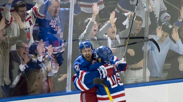 The New York Rangers' Derek Stepan is corralled by teammate Derick Brassard after scoring the second goal against Tampa Bay Lightning in the second period of Game 2 of the Eastern Conference finals at Madison Square Garden on Monday, May 18, 2015.