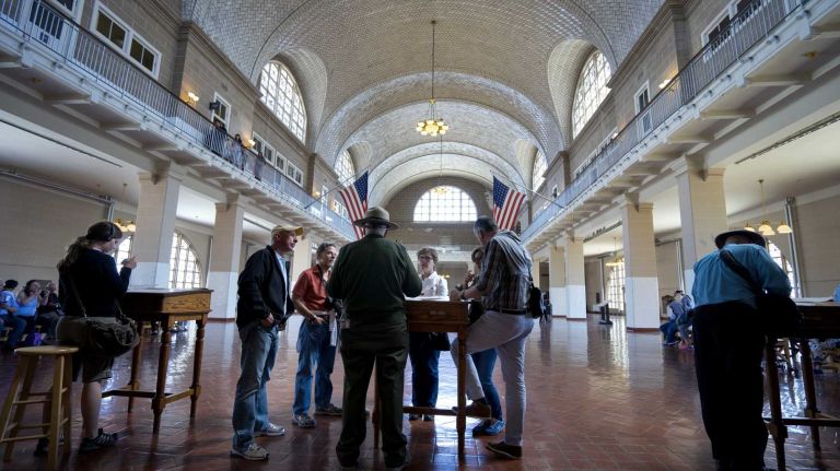 Visitors stand in The Registry Room Ellis Island May 7, 2015. A new nearby display, called The Peopling of America Center, will open May 20th and is a new installation that will feature exhibitions chronicling immigration to America before the processing station at Ellis Island opened in 1892 and after it closed in 1954, making it the nation's official museum chronicling all immigration from the colonial era to today.
