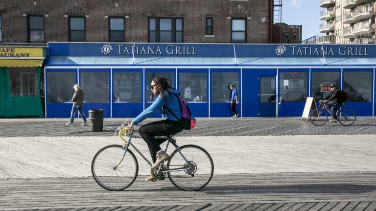 A woman ride her bike along the boardwalk in Brighton Beach in Brooklyn on April 28, 2015. By Anthony Lanzilote