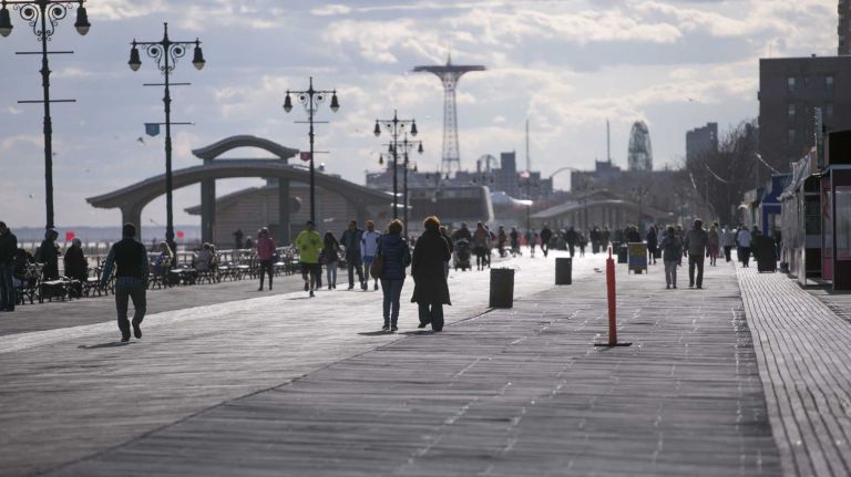 People walk along the boardwalk in Brighton Beach in Brooklyn on April 28, 2015. By Anthony Lanzilote