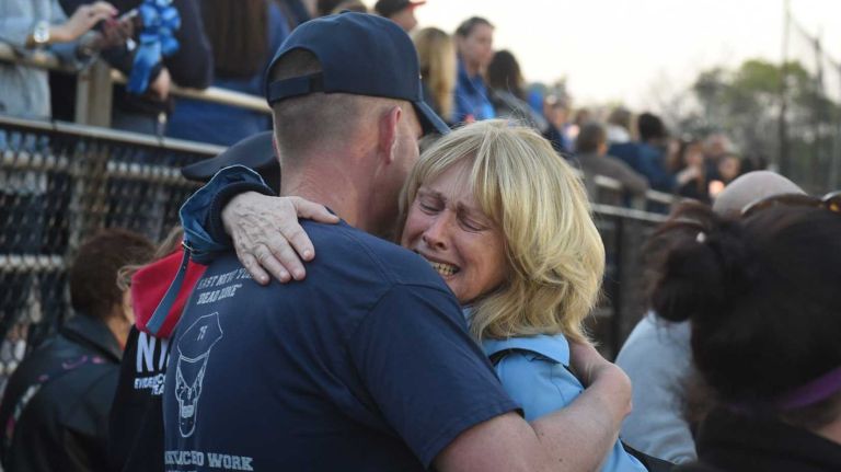 Family and friends of slain NYPD Police officer Brian Moore gather at a memorial service for him on the football field of Plainedge High School on Monday, May 4, 2015.