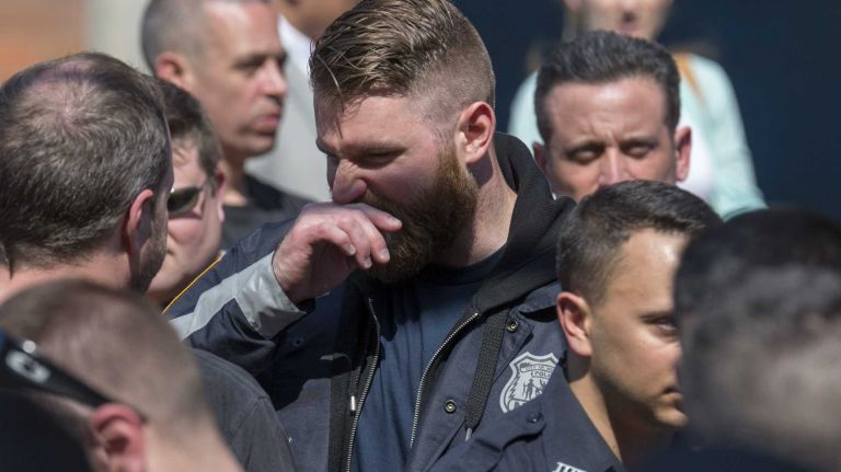An NYPD officer reacts outside of Jamaica Hospital in Queens after Officer Brian Moore died at the hospital on Monday, May 4, 2015.